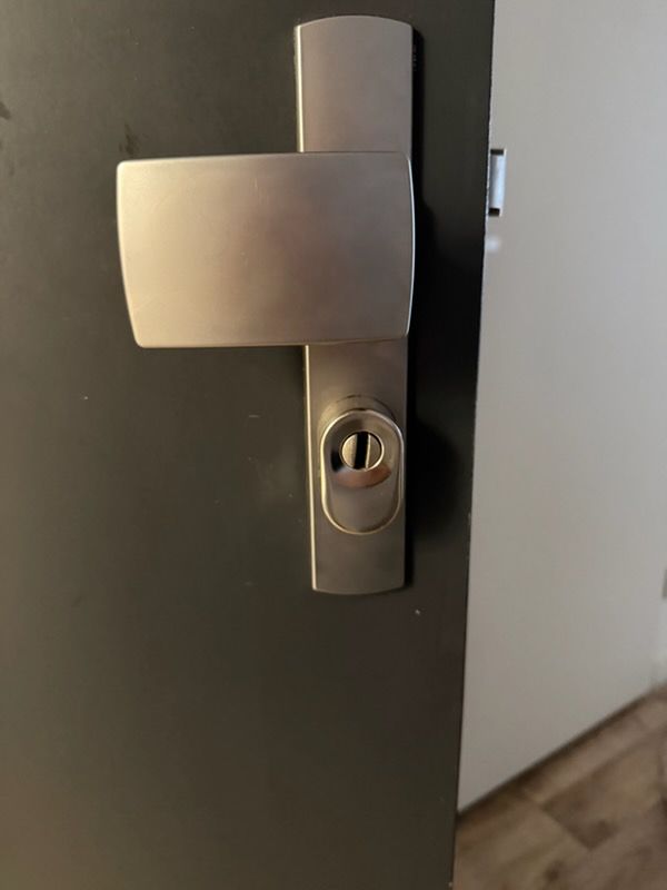 Poignée blindée et protecteur de cylindre posés sur une porte d'entrée
