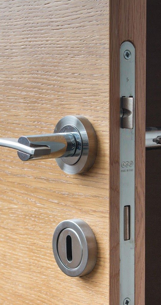 Serrure encastrée et gâche visibles dans le montant d'une porte