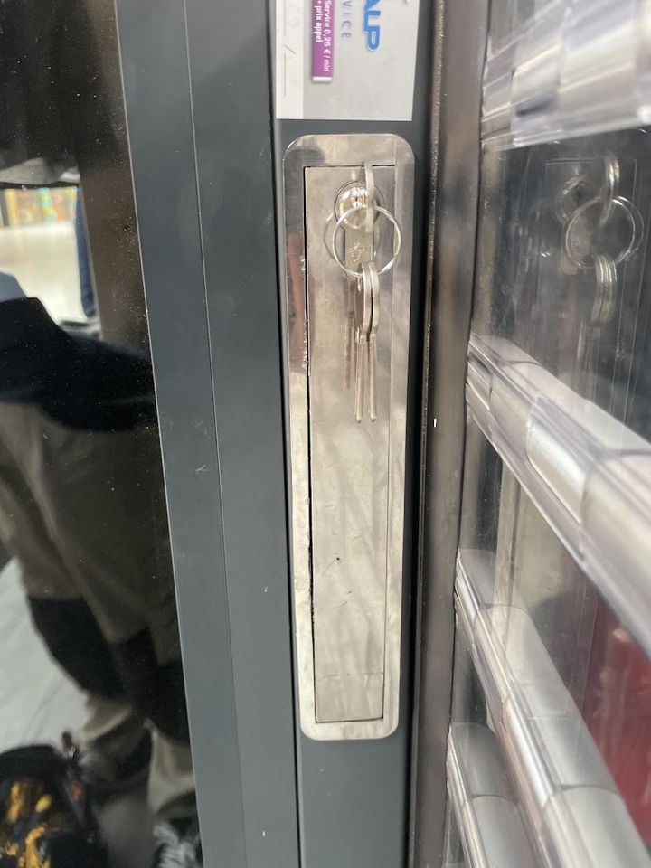 Serrure en applique sur une porte de commerce, clés dans le barillet
